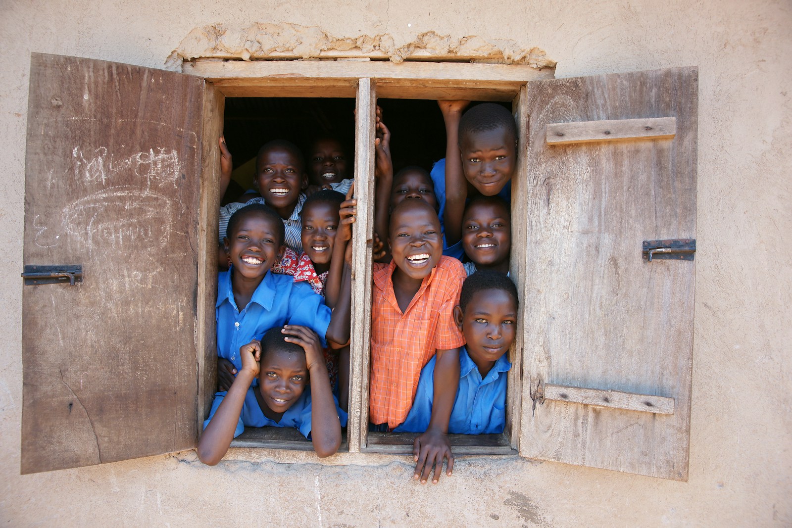 A group of young children standing in a window